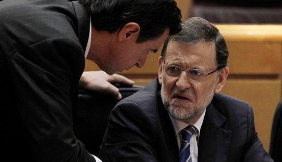 Spain's Prime Minister Mariano Rajoy, right, speaks with Spain's Industry, Commerce, Tourism Jose Manuel Soria, left, during a Spanish Parliament session in Madrid, Spain, Thursday, Aug. 1, 2013.  Rajoy brushed off demands he should resign after text messages emerged showing him comforting a former political party treasurer under investigation over a slush fund and secret Swiss bank accounts. The spectacle of alleged greed and corruption has enraged Spaniards hurting from austerity and sky high unemployment. (AP Photo/Andres Kudacki)