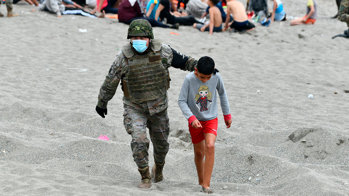 Un militar acompañando a un menor durante la crisis migratoria en Ceuta. ARCHIVO