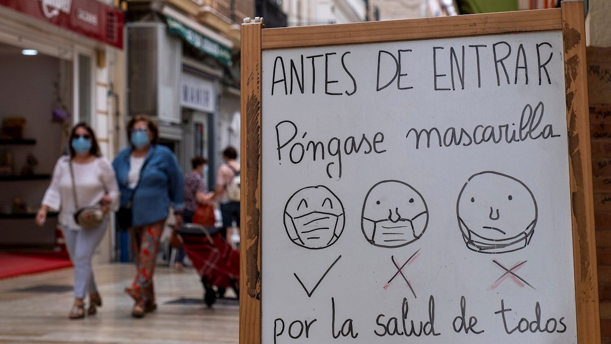 Un cartel colocado a la entrada de un establecimiento de Huelva informa a los clientes de la obligatoriedad y del correcto uso de las mascarillas. — EFE/JULIÁN PÉREZ