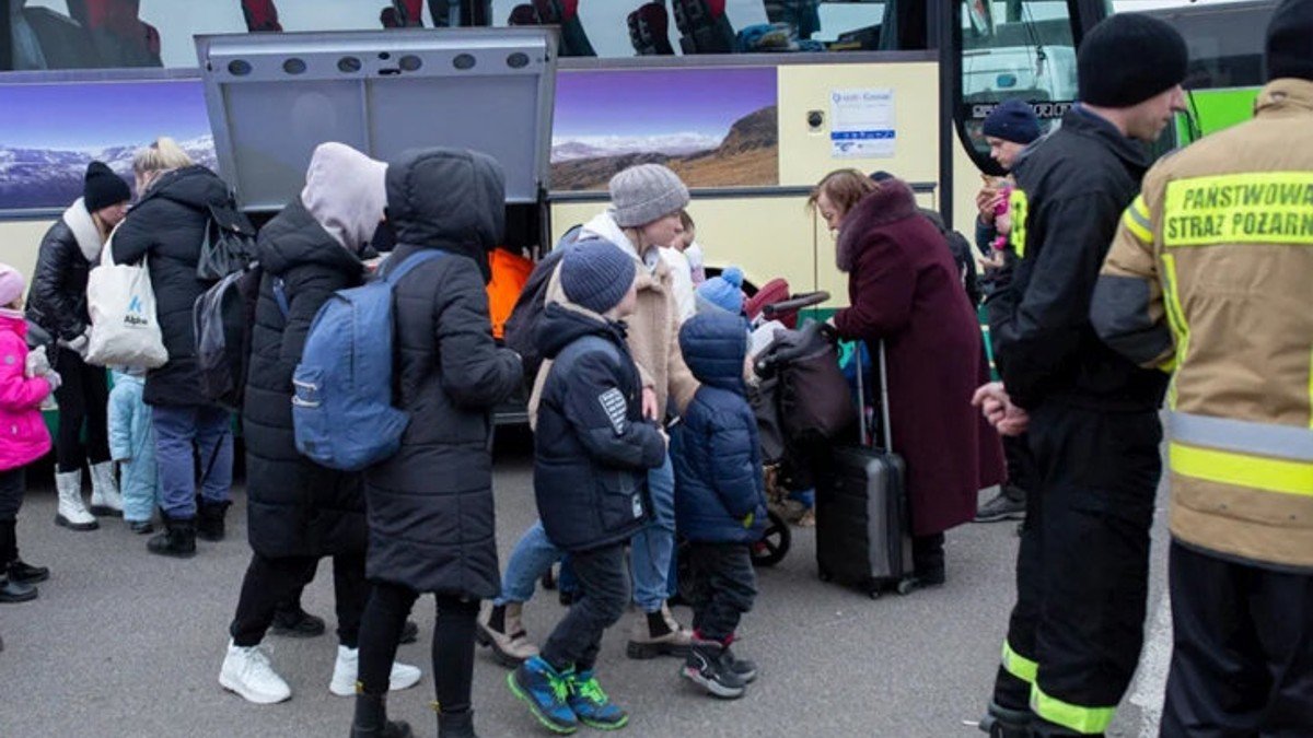 Niños y niñas preparándose para subir a un autobús en Ucrania para huir de la guerra. - ACNUR | Valerio Muscella