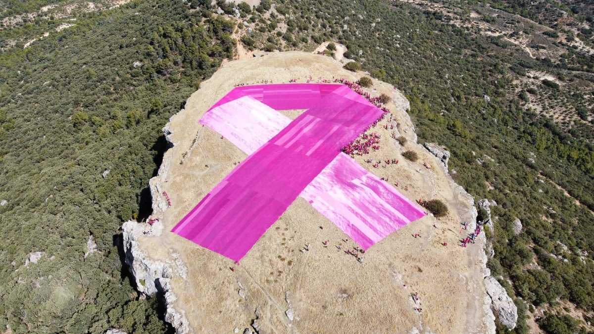 Más de 500 voluntarios han desplegado el enorme lazo rosa en la cima de uno de los cerros gemelos. 