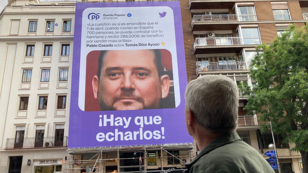 Podemos ha colgado en Madrid una lona con la imagen del hermano de la presidenta y una cita de Casado. | TWITTER