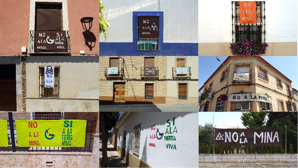 Balcones, fachadas y ventanas lucen pancartas contra la minería de tierras raras.